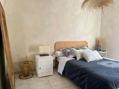 une chambre avec un lit et une table de chevet avec une lampe dans l'établissement Villa Évasion Saint-Cyrienne, à Saint-Cyr-sur-Mer