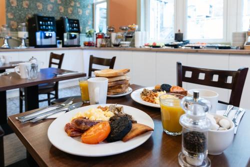 a table with plates of breakfast food and drinks at Scotland's Spa Hotel in Pitlochry
