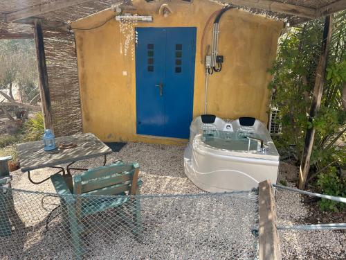 a bathroom with a tub and a blue door at Carmey Avdat Farm in Midreshet Ben Gurion