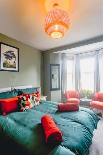 a bedroom with a large green bed with red pillows at Smarties Guest House in Newquay