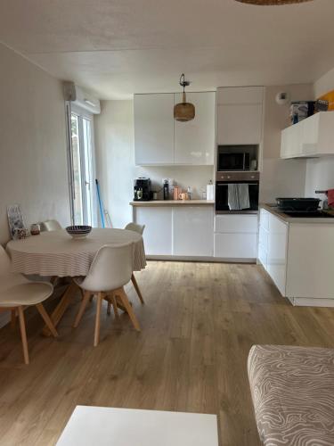 une cuisine et un salon avec une table et des chaises dans l'établissement Cosy Rez de jardin - Clim & Parking, à Aix-en-Provence