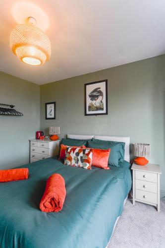 a bedroom with a large blue bed with orange pillows at Smarties Guest House in Newquay