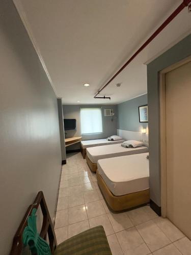 a room with three beds in a room at Ciello Accomodation in Cagayan de Oro