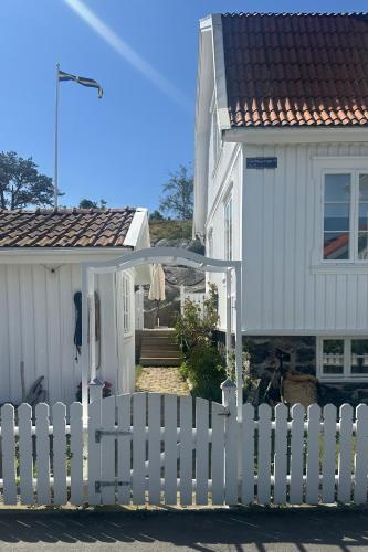 a white picket fence in front of a house at Archipelago villa with seaview and 2min to baths in Asperö