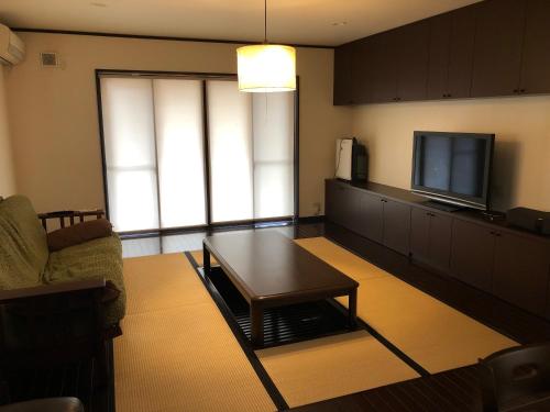 a living room with a coffee table and a flat screen tv at 花見宿hanamiyado叡電eiden木野kino-木野駅徒歩1分1minutes walk from kinostation-衣類乾燥機有-無料駐車場有-宿泊税込 in Kyoto