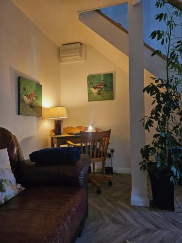 a living room with a couch and a table at The Retreat at Plover Cottage Lindley in Huddersfield