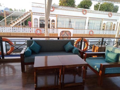 a couch and two chairs and a table on a balcony at Nile Dahabiya Sailing boat 3 nights Every Friday from Aswan to Luxor in Aswan