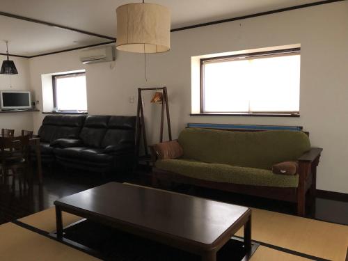 a living room with a couch and a coffee table at 花見宿hanamiyado叡電eiden木野kino-木野駅徒歩1分1minutes walk from kinostation-衣類乾燥機有-無料駐車場有-宿泊税込 in Kyoto