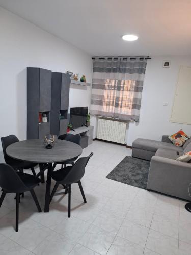 ein Wohnzimmer mit einem Tisch und einem Sofa in der Unterkunft Valle Cinque in Fano
