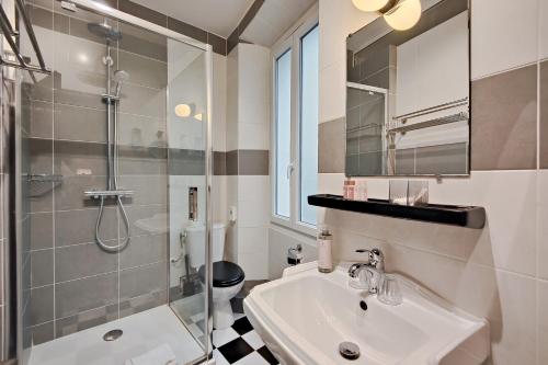 a bathroom with a sink and a shower and a toilet at Hôtel de France, un hôtel AMMI in Nice