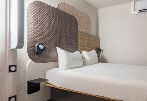 a bedroom with a bed with white sheets and pillows at B&B HOTEL Troyes Centre in Troyes