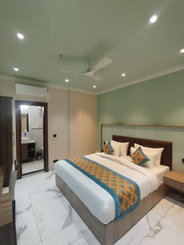 a bedroom with a large bed and a bathroom at The SM Hotel By RMR Hotels in New Delhi