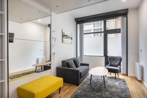 un salon avec un canapé et une chaise dans l'établissement Cosy studio 1 - Grenelle Eiffel Tower, à Paris
