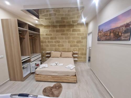 Un dormitorio con una cama y una pared de piedra. en Love is in the air, en Palermo