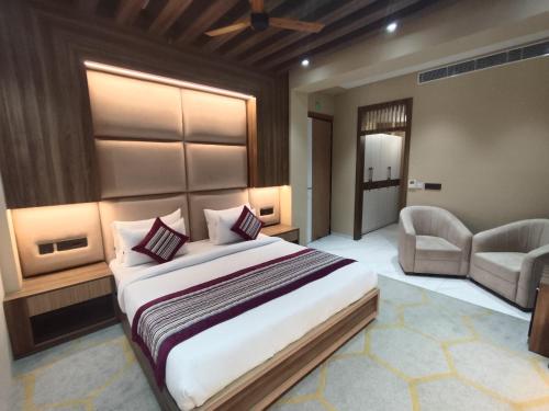 a bedroom with a bed and a couch and a chair at The SM Hotel By RMR Hotels in New Delhi