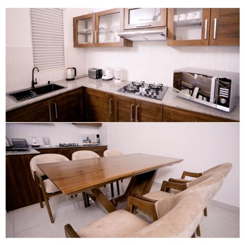 a kitchen with a wooden table with chairs and a counter top at Diyawanna Villa - Deluxe Double Room in Colombo in Sri Jayewardenepura Kotte
