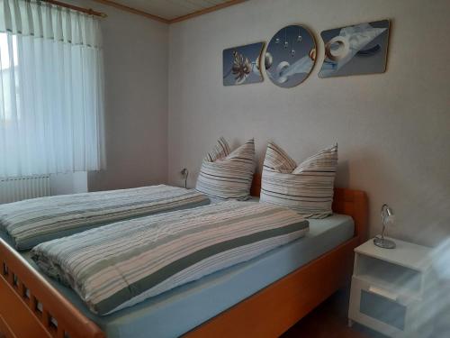 a bedroom with a bed with pillows and a clock at Ferienwohnung mit Terrasse in Insheim