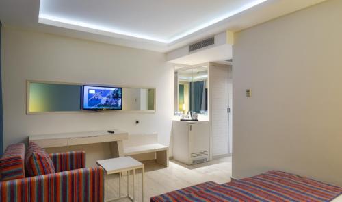 a living room with a couch and a tv on the wall at Duja Bodrum in Torba