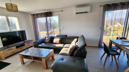 un soggiorno con un divano e una TV di Gîte cosy près de la mer - Maison familial tout équipé - Côte d'Albâtre a Cany-Barville