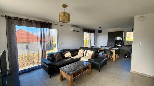 un soggiorno con un divano e un tavolo di Gîte cosy près de la mer - Maison familial tout équipé - Côte d'Albâtre a Cany-Barville