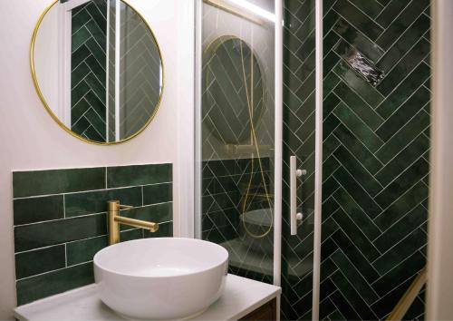 ein Badezimmer mit Waschbecken und Spiegel in der Unterkunft Le Duc d'Anjou Classé 3 étoiles Confort & Charme au cœur de ville in Versailles