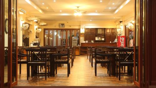 Un comedor con mesas y sillas en un restaurante. en Poonnagunn hotel, en Mae Sot