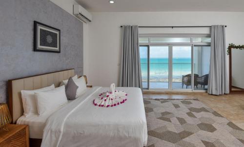 a bedroom with a bed and a large window at Zanzibar DT Beachfront Villa in Mkunguni