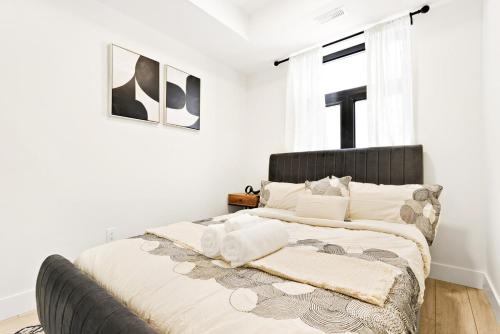 Un dormitorio con una cama con paredes blancas y una ventana. en Cozy 2BR Suite with Parking & Close to Niagara Falls and Sleeps 6 Guests, en Niagara Falls