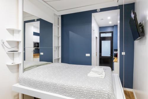 - une chambre avec des murs bleus et un lit avec un miroir dans l'établissement Cosy studio 2 - Grenelle Eiffel Tower, à Paris