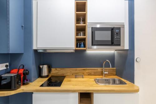 une cuisine avec un évier et un micro-ondes dans l'établissement Cosy studio 2 - Grenelle Eiffel Tower, à Paris