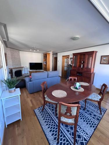 a living room with a table and a blue couch at Casa la Plaza in Molinaseca