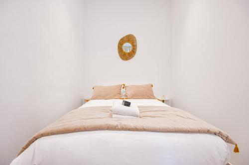 un lit dans une chambre blanche avec un miroir au mur dans l'établissement Appart haut standing 1 ch clim proche Vieux-Port, à Marseille