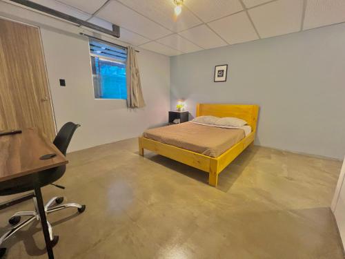 a bedroom with a bed and a desk in it at Hotel Citadin Zona 4 in Guatemala