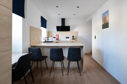 a kitchen with blue chairs and a kitchen island at NOMAD APARTMENTS - Côté Meuse in Dinant