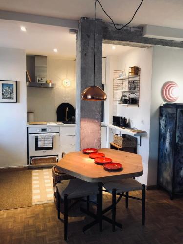 - une cuisine avec une table en bois et des plaques rouges dans l'établissement Marseille Joliette Panier, vue mer et Terrasse T1, à Marseille