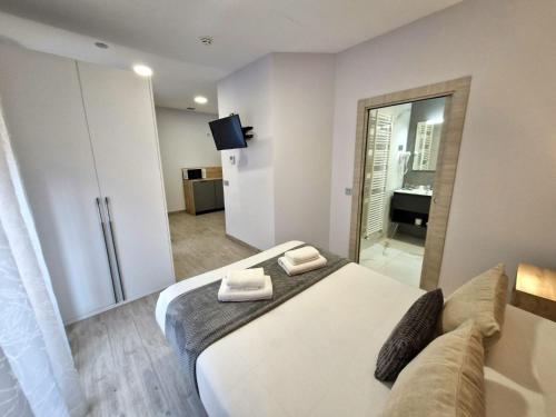 a bedroom with a bed with two towels on it at Feeling Home - Suites&Rooms in León