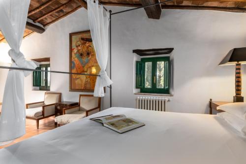 グレーヴェ・イン・キアンティにあるVilla Rosanoの白いベッドと椅子のある寝室