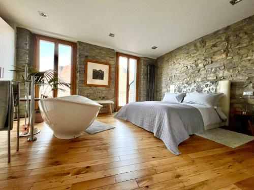 a bedroom with a large bed and a bath tub at Romantic & Private Lake Como village house in Pognana Lario