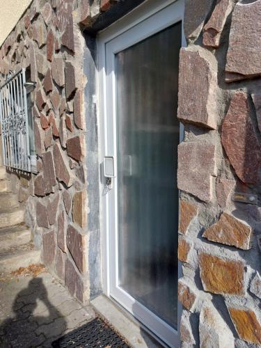 a door in a stone wall with a window at Ferienwohnung Thiel in Much