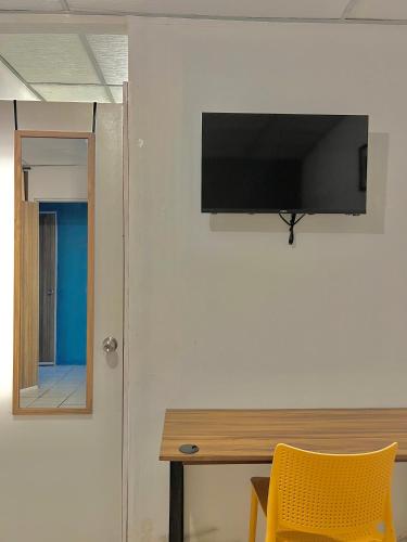 a flat screen tv hanging on a wall next to a desk at Hotel Citadin Zona 4 in Guatemala