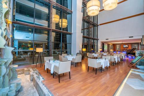 a dining room with white tables and chairs at Anemon Grand Eskişehir Otel in Eskisehir