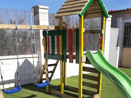 a playground with a slide and a swing at Casa Rural Kentia in Ciudad Real