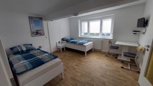 a bedroom with a bed and a desk and a window at Apartment in Freimersheim