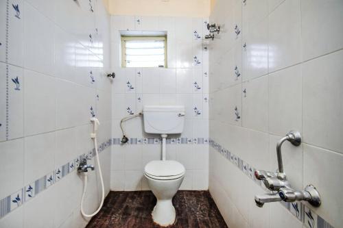 a bathroom with a toilet and a sink at FabHotel Aditya Yatri Nivas - Nr Tirupati Railway Station in Tirupati