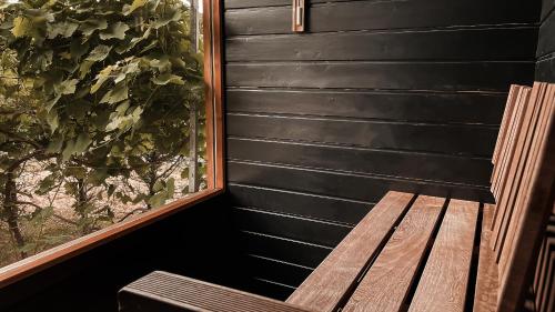 a wooden bench sitting in front of a window at APARTMENTS mit PRIVAT SPA - Haus LuKa in Fischbach