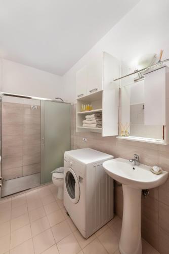 a bathroom with a washing machine and a sink at Dolce Casa Suite1 in Afantou