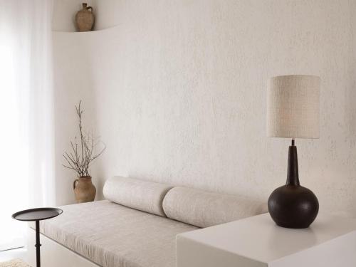 a living room with a couch and a lamp on a table at Boheme Mykonos Town - Small Luxury Hotels of the World in Mýkonos City