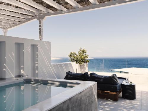 a house with a swimming pool with a view of the ocean at Boheme Mykonos Town - Small Luxury Hotels of the World in Mýkonos City
