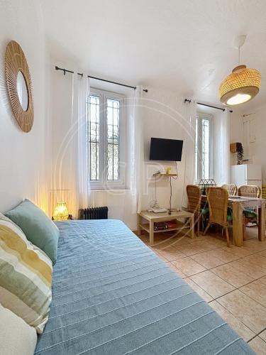 une chambre avec un lit, une table et une télévision dans l'établissement EDEN PLACE un petit coin de Paradis by LaConciergerie13, à La Ciotat