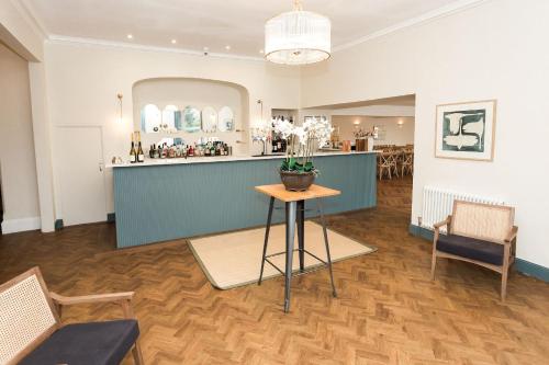 a room with a bar and a table and chairs at Torr House Hotel in Dumfries